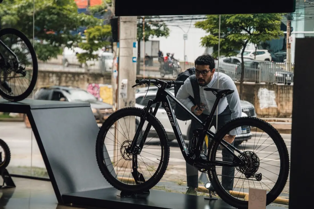 Cliente conhecendo uma bike Sense na vitrine da S2 Bike Shop Montes Claros